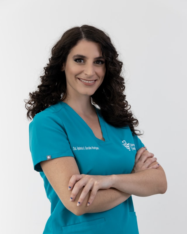 Retrato de la Dra. Camila Reyes, odontóloga, con uniforme clínico